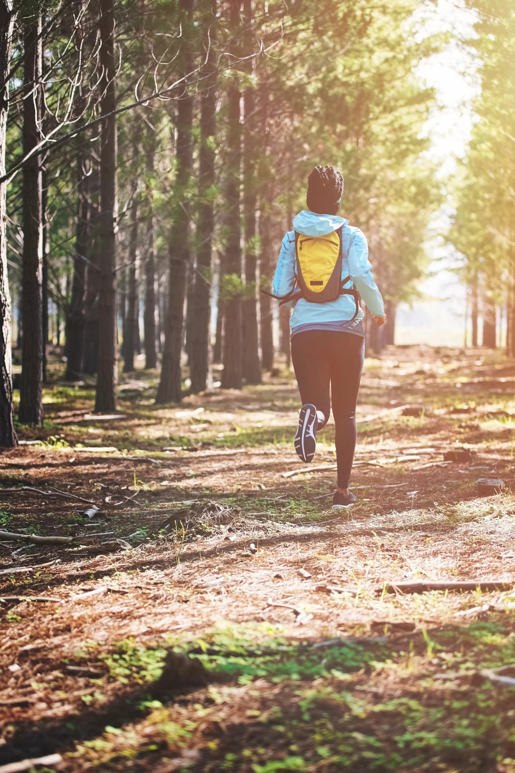 An adult running on a woodland trail